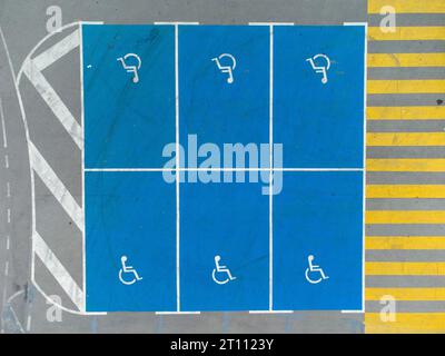 Parcheggio vuoto con posti auto per disabili, vista aerea dall'alto. Foto Stock