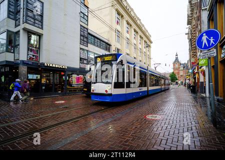 Un tram accelera Leidsestraat davanti a uno Starbucks Foto Stock