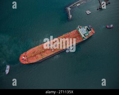 Vista aerea dall'alto della nave cisterna con rimorchiatore di scorta che lascia il porto Foto Stock