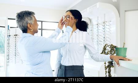 Optometria, servizio oculistico o donna felice con occhiali per la visione in un negozio di ottica o occhiali al dettaglio. Donne, scelta o cliente con nuovi occhiali Foto Stock