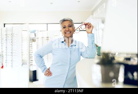 Acquista ritratti, occhiali e donna felice, optometrista o manager per il benessere visivo, il supporto ottico o gli occhiali. Esperienza lavorativa, occhiali da vista e. Foto Stock