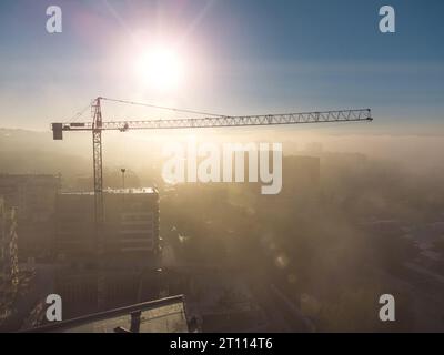 gru a torre su un cantiere con vista aerea densa nebbia al mattino Foto Stock