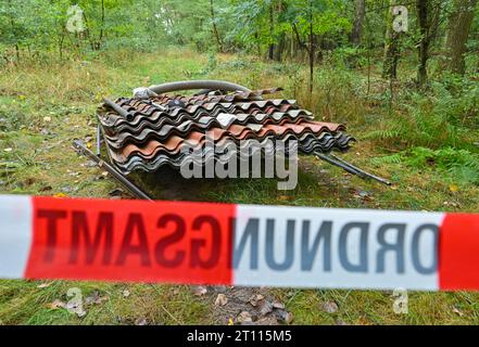 10 ottobre 2023, Brandeburgo, Fürstenwalde: I pannelli del tetto in amianto e altri rifiuti sono illegalmente smaltiti in una foresta nel distretto di Oder-Spree. Il sito è già stato cordonato dall'ufficio dell'ordine pubblico. Sempre più spazzatura finisce nelle foreste del Brandeburgo. Oltre ai rifiuti edili, agli pneumatici e ai rifiuti ingombranti, anche i rifiuti pericolosi finiscono nel paesaggio. Foto: Patrick Pleul/dpa Foto Stock