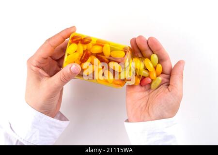 Vitamine gommose e supplemento per adulti. La donna mangia gelatina dolce multivitaminica caramelle microelementi da pillole trasparenti bottiglia, farmaci moderni e. Foto Stock