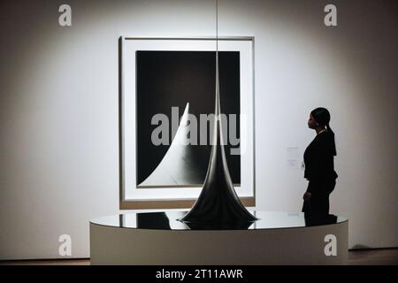 Londra, Regno Unito. 10 ottobre 2023. Il personale posa con superficie di rivoluzione con curvatura negativa costante, 2006 (primo piano) e un'immagine nella serie forme concettuali/forme matematiche:superfici, 2004 (sfondo) nell'anteprima. Anteprima della mostra "Hiroshi Sugimoto: Time Machine" e foto alla Hayward Gallery. La mostra si svolgerà fino al 7 gennaio 2024. Crediti: Imageplotter/Alamy Live News Foto Stock