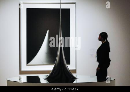 Londra, Regno Unito. 10 ottobre 2023. Il personale posa con superficie di rivoluzione con curvatura negativa costante, 2006 (primo piano) e un'immagine nella serie forme concettuali/forme matematiche:superfici, 2004 (sfondo) nell'anteprima. Anteprima della mostra "Hiroshi Sugimoto: Time Machine" e foto alla Hayward Gallery. La mostra si svolgerà fino al 7 gennaio 2024. Crediti: Imageplotter/Alamy Live News Foto Stock