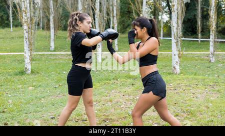 Due giovani pugili che si allenano all'aperto. Allenamento di pugilato con sparring e pugni. Foto Stock