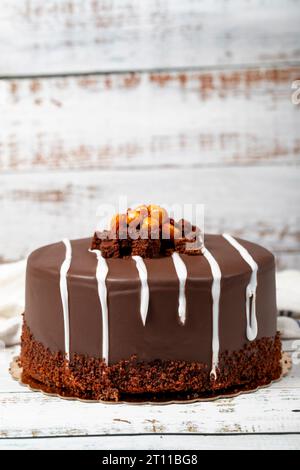 Torta al cioccolato. Torta di compleanno con panna e cioccolato su fondo di legno. prodotti per pasticceria. Primo piano Foto Stock