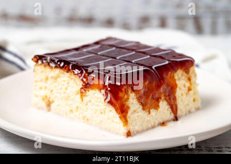 Tres leches cake. Fette di torta trilece con latte e caramello su fondo di legno. prodotti per pasticceria. Primo piano Foto Stock