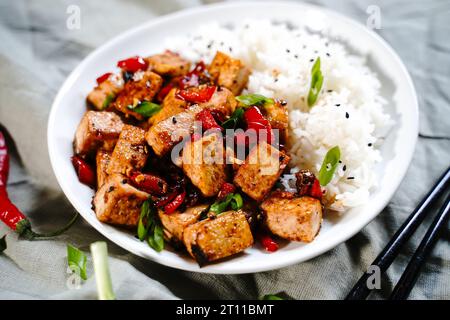 Frittura di tofu Szechuan servita con riso jasmin, fuoco selettivo Foto Stock