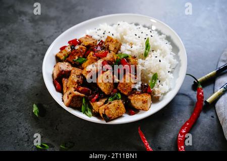 Frittura di tofu Szechuan servita con riso jasmin, fuoco selettivo Foto Stock