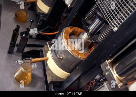 Produzione locale di piccoli oli di semi. Processo di estrazione dell'olio extra vergine di lino fresco. Foto Stock