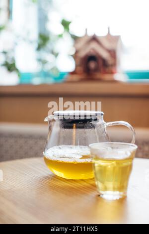 Primo piano del tè caldo in una teiera di vetro su un tavolo in un caffè. Foto Stock