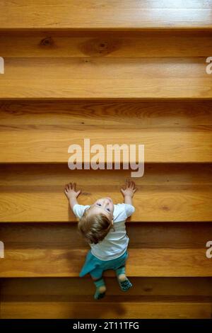 Il bambino si prepara a salire coraggiosamente una rampa di scale Foto Stock