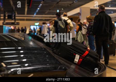 BERLINO, GERMANIA - 9 OTTOBRE 2023: Valigia sul nastro trasportatore bagagli nel ritiro bagagli in aeroporto Foto Stock