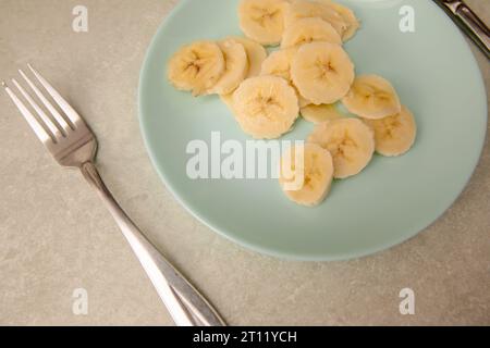 Fette di banana nel recipiente. Sfondo cucina. Messa a fuoco selettiva. Foto Stock