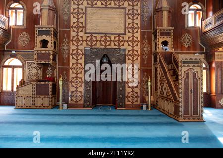 interni masjid in legno con tappeto blu Foto Stock