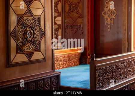 interni masjid in legno con tappeto blu Foto Stock