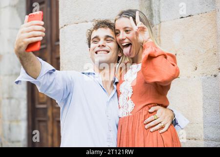 I giovani che si divertono con espressioni divertenti che fanno un selfi Foto Stock