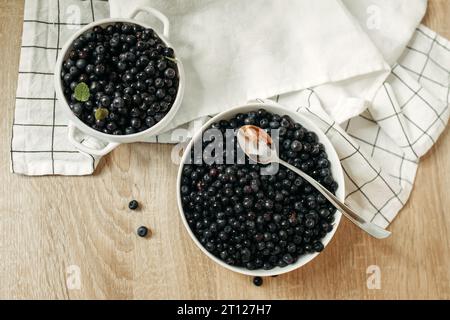 Ci sono piatti di mirtilli maturi sul tavolo della cucina. Prodotti biologici, vista dall'alto. Foto Stock