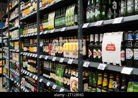 Bottiglie di birra di vari marchi esposte ordinatamente sugli scaffali dei supermercati a Bucarest, Romania, il 12 settembre 2023 Foto Stock