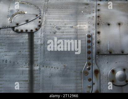 Sfondo metallico con viti e rivetti. Un frammento della fusoliera di un vecchio combattente. Foto Stock