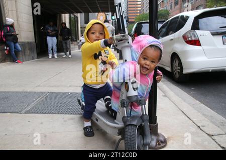 I bambini migranti giocano fuori dall'Inn of Chicago, che si trova a pochi passi dal Magnificent Mile e dal quartiere finanziario centrale, come visto qui il 10 ottobre 2022. Per oltre un anno, l'Inn of Chicago ha ospitato oltre 1.500 nuovi arrivi, questo ex hotel boutique è circondato da hotel di lusso, ristoranti ed è una delle principali aree turistiche. Due consiglieri del centro chiedono la chiusura di questo rifugio, citando crescenti lamentele da parte dei vicini. (Foto di: Alexandra Buxbaum/Sipa USA) credito: SIPA USA/Alamy Live News Foto Stock