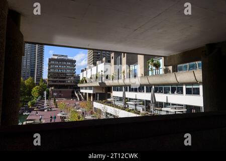 Persone sedute sulla terrazza sul lago di fronte al Barbican Centre. Il Barbican Centre è un rinomato centro artistico parte della tenuta Barbican, a Foto Stock