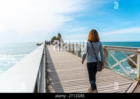 Una giovane donna che passeggia insieme lungo il ponte di legno a Plage du Port Vieux a Biarritz, in vacanza nel sud-est della Francia. Biarritz, dipartimento Foto Stock