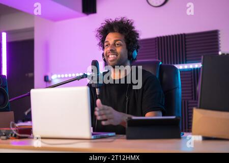Creatore di contenuti durante una lezione di streaming online in studio con luci al neon Foto Stock