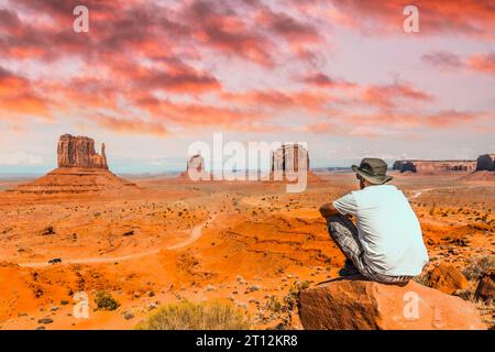 Un ragazzo con una t-shirt bianca seduto al centro della foto su una pietra nel Monument Valley National Park nel centro visitatori. Utah Foto Stock