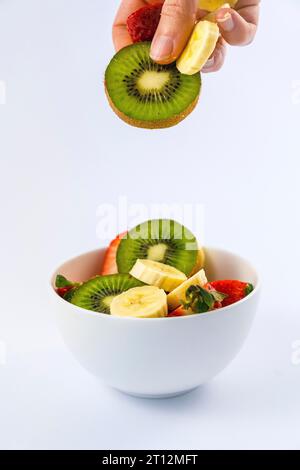 Ricetta di un'insalata di frutta con kiwi, fragole, banane Foto Stock