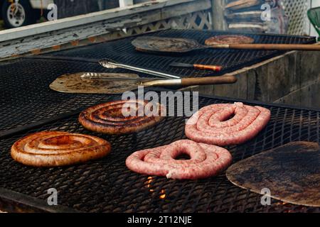 Fiera di Deerfield, New Hampshire 2023 - rotoli di salsiccia di maiale cucinati su una griglia a legna all'esterno di una tenda alimentare. Foto Stock