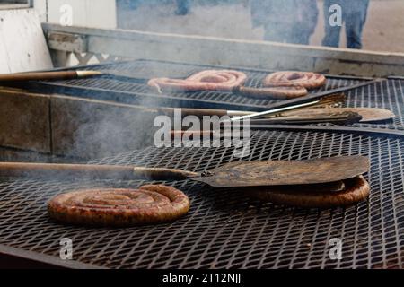 Fiera di Deerfield, New Hampshire 2023 - rotoli di salsiccia di maiale cucinati su una griglia a legna all'esterno di una tenda alimentare. Foto Stock