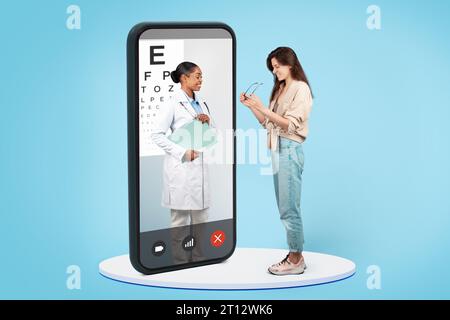 Medico di colore sorridente, specializzato come oftalmologo, assiste sapientemente la paziente nella scelta di nuovi occhiali da vista Foto Stock