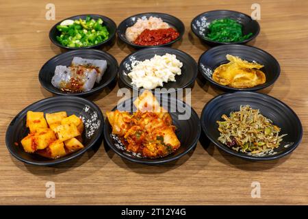 Vari contorni coreani in stile casalingo, tra cui kimchi, ravanelli sottaceto, acciughe, konjac, pasta di fagioli piccanti, e alghe marine. In genere servita con ogni Foto Stock