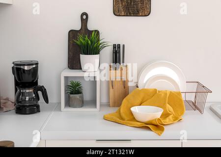 Banchi da cucina bianchi con macchina per il caffè, portapiastre e utensili Foto Stock