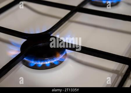 Donna che accende il bruciatore a gas sulla stufa Foto Stock