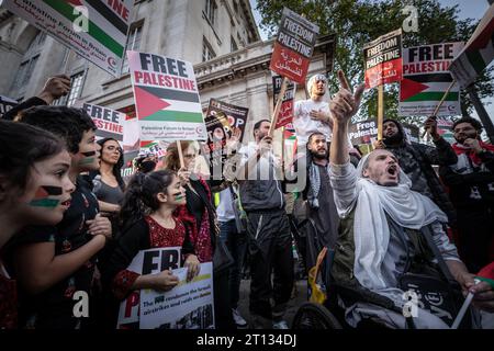 Londra, Regno Unito. 9 ottobre 2023. I sostenitori della Palestina si riuniscono per una manifestazione di massa vicino all'Ambasciata di Israele a High Street Kensington in un evento organizzato dalla coalizione Stop the War. I manifestanti hanno cantato “Israele è uno stato terroristico” e “Palestina libera” mentre lasciavano fuochi d’artificio e fuochi d’artificio. Il 7 ottobre Hamas ha organizzato un attacco multifronte a sorpresa da Gaza contro Israele e, in risposta, il primo ministro israeliano, Benjamin Netanyahu, ha dichiarato che Israele è in guerra e che i palestinesi "pagheranno un prezzo pesante”. Crediti: Guy Corbishley/Alamy Live News Foto Stock