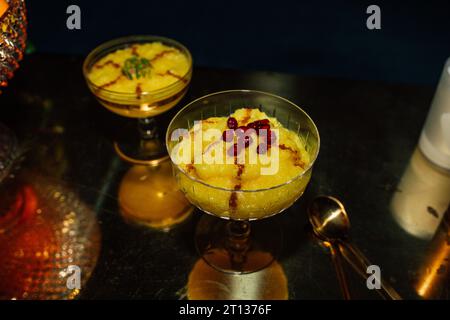Sholeh Zard, budino di riso allo zafferano persiano, dessert con cannella, melograno e contorno al pistacchio Foto Stock