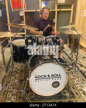 Cleveland, Ohio, USA - 4 agosto 2023: Uomo che suona su un set di batteria in una stanza della Hall of Fame del rock and roll. Foto Stock