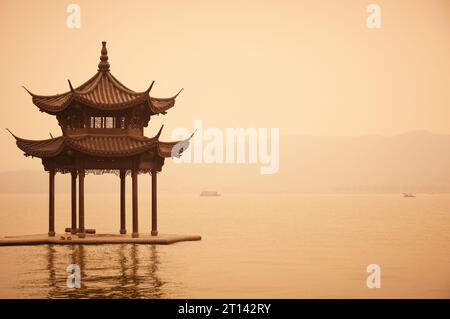 Gazebo cinese tradizionale in legno sulla costa del Lago Ovest, parco pubblico nella città di Hangzhou, Cina. Foto Stock