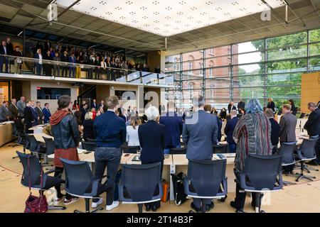 Kiel, Germania. 11 ottobre 2023. I membri del parlamento statale dello Schleswig-Holstein si alzano per un minuto di silenzio nella sala plenaria. L'occasione era un'ora di attualità dal titolo "solidarietà con Israele. Crediti: Frank Molter/dpa/Alamy Live News Foto Stock