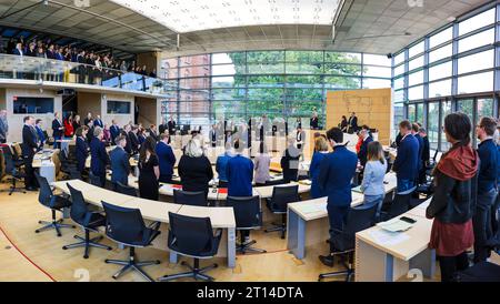 Kiel, Germania. 11 ottobre 2023. I membri del parlamento statale dello Schleswig-Holstein si alzano per un minuto di silenzio nella sala plenaria. L'occasione era un'ora di attualità dal titolo "solidarietà con Israele. Crediti: Frank Molter/dpa/Alamy Live News Foto Stock