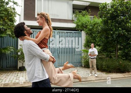 Felice ed eccitata giovane coppia che festeggia l'acquisto di una nuova casa Foto Stock