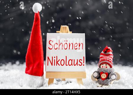11 ottobre 2023: St Giorno del Nicola il 6 dicembre, cappello di Natale e elfo in sci accanto a una tavola con il testo: Happy St Nicholas PHOTOMONTAGE *** Nikolaustag am 6 Dezember, Weihnachtsmütze und Wichtel auf Ski neben einer Tafel mit testo: schönen Nikolaus FOTOMONTAGE Credit: Imago/Alamy Live News Foto Stock