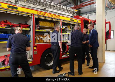 Il Principe di Galles parla con i vigili del fuoco durante una visita al Milton Keynes Blue Light Hub nel Buckinghamshire, per evidenziare l'importanza di sostenere la salute mentale dei soccorritori durante la settimana della giornata mondiale della salute mentale. Data foto: Mercoledì 11 ottobre 2023. Foto Stock