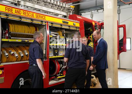 Il Principe di Galles parla con i vigili del fuoco durante una visita al Milton Keynes Blue Light Hub nel Buckinghamshire, per evidenziare l'importanza di sostenere la salute mentale dei soccorritori durante la settimana della giornata mondiale della salute mentale. Data foto: Mercoledì 11 ottobre 2023. Foto Stock