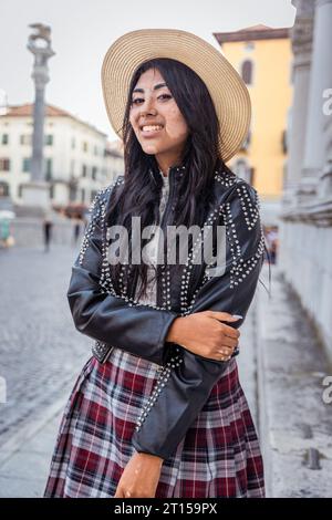 Foto verticale di una ragazza ispanica sorridente nel centro della città Foto Stock