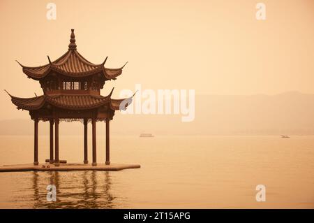 Gazebo cinese tradizionale in legno sulla costa del Lago Ovest, parco pubblico nella città di Hangzhou, Cina. Foto Stock